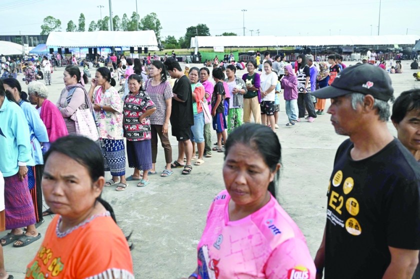 Displaced residents queue for food at an evacuation centre in the Thai border province of Buriram. — AFP