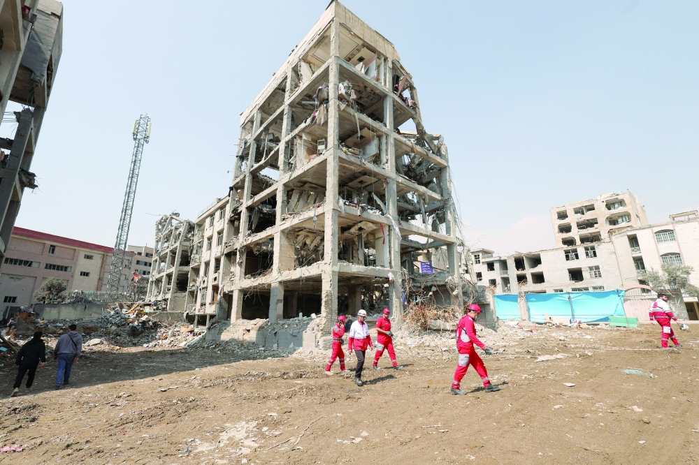 A Red Crescent rescue team works next to a building that was damaged by a strike, in Tehran. — Reuters