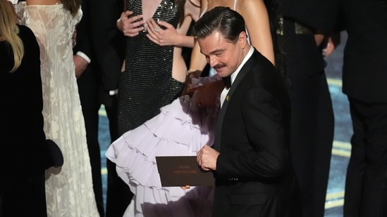 Leonardo DiCaprio holds the envelope announcing "One Battle After Another" as the winner of the award for best picture during the Oscars on Sunday.